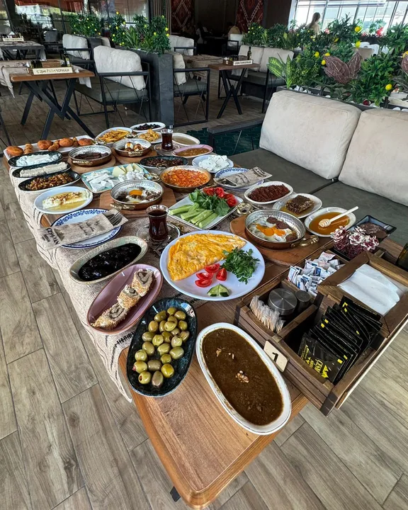 Çeşm-i Van Sofrası'nda kurulu Van kahvaltısı sofrası: bal, kaymak, otlu peynir, murtuga ve çeşitli kâseler