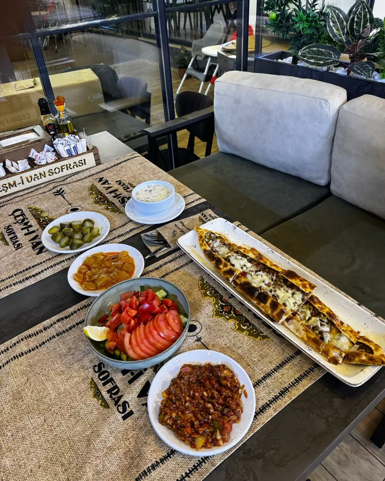 Uzun tepside odun ateşinde pişmiş pide ve yanında meze tabakları