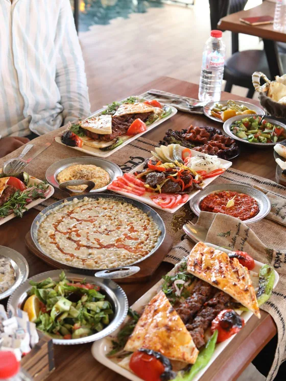 Salonda uzun bir masa boyunca kurulmuş kalabalık sofra